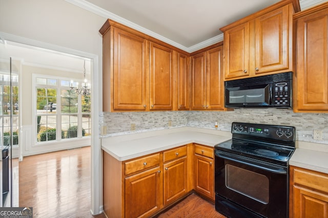 kitchen featuring light hardwood / wood-style floors, black appliances, ornamental molding, and a chandelier