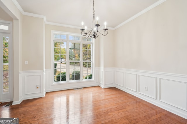 unfurnished dining area featuring light hardwood / wood-style floors, a notable chandelier, plenty of natural light, and crown molding