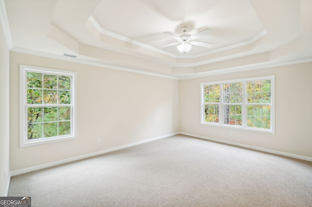 unfurnished room featuring carpet, crown molding, a healthy amount of sunlight, and ceiling fan