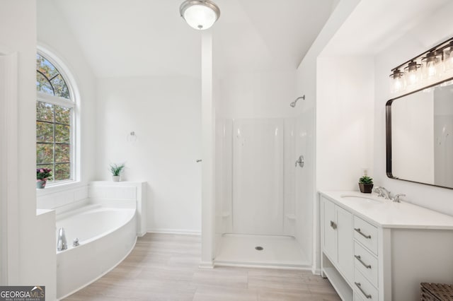 bathroom featuring vanity, lofted ceiling, and independent shower and bath