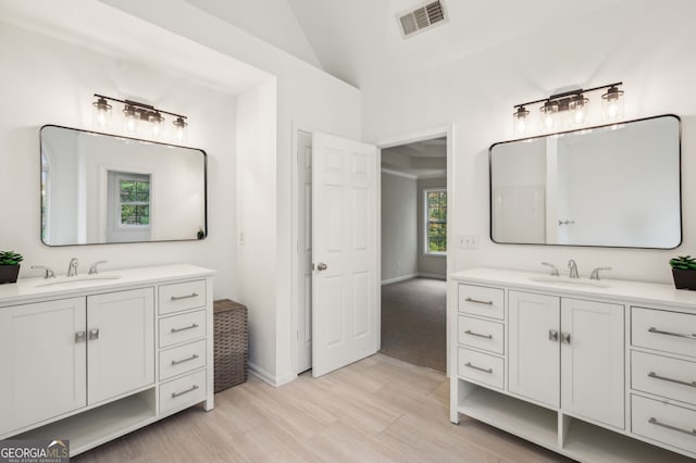 bathroom with vanity, wood-type flooring, and lofted ceiling