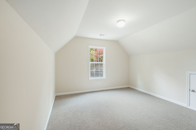 additional living space featuring lofted ceiling and carpet