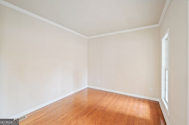 unfurnished room with ornamental molding and hardwood / wood-style floors