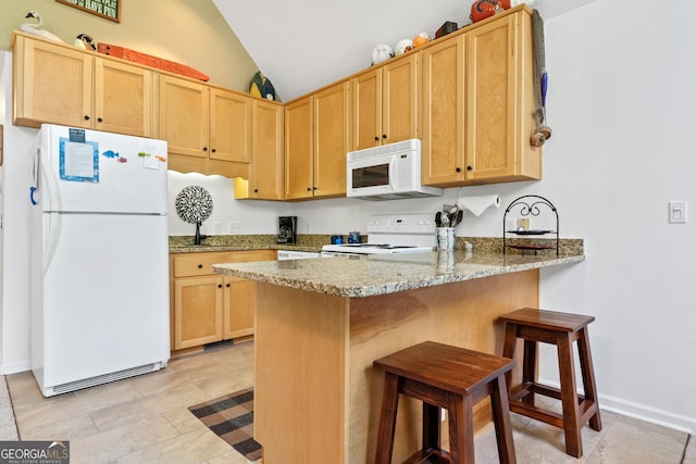 kitchen featuring white appliances, kitchen peninsula, light stone counters, vaulted ceiling, and light brown cabinetry