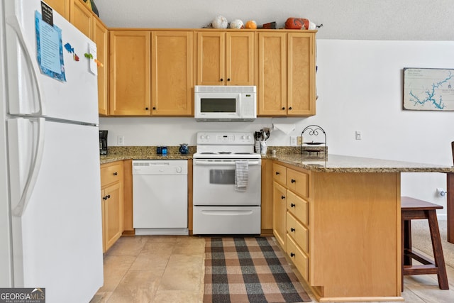 kitchen featuring white appliances, a kitchen breakfast bar, kitchen peninsula, dark stone counters, and a textured ceiling