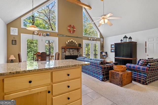 kitchen with ceiling fan, high vaulted ceiling, a fireplace, and light tile patterned floors