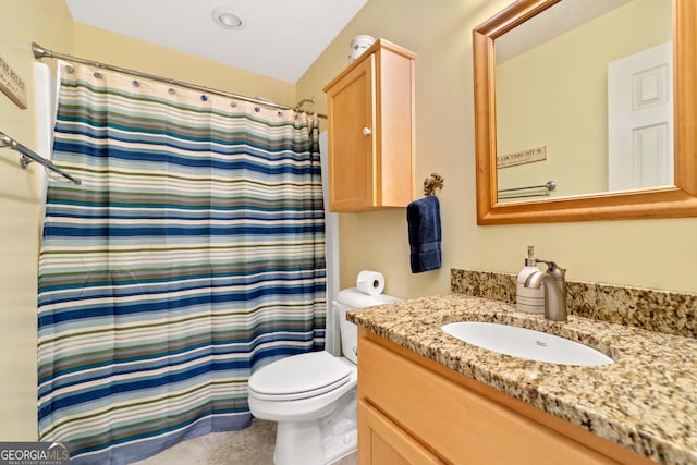 bathroom with a textured ceiling, walk in shower, vanity, and toilet