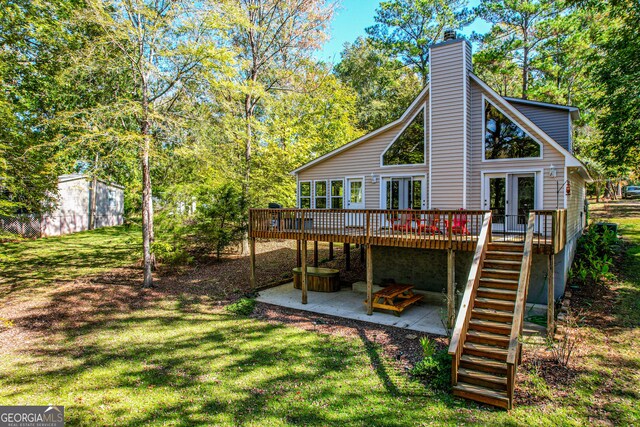 rear view of property with a lawn, french doors, a patio, and a wooden deck