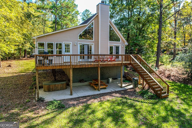 back of house with french doors, a wooden deck, a yard, and a patio area