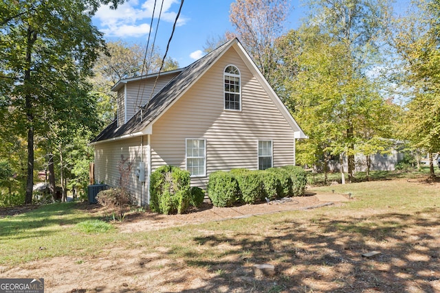 view of property exterior with central AC and a lawn