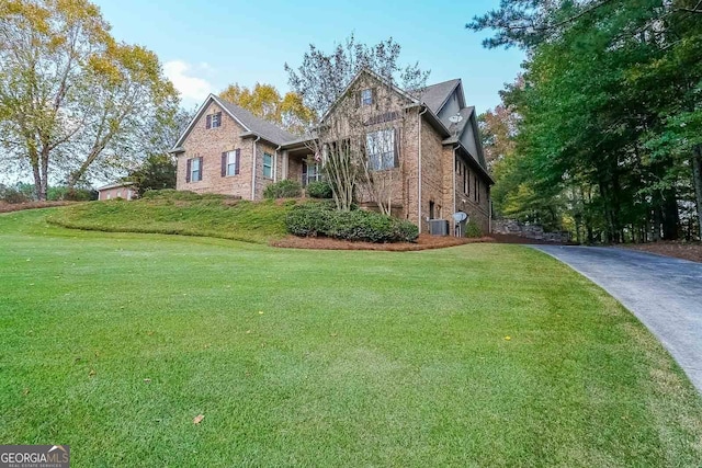 view of front of home with a front lawn and cooling unit