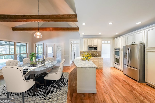 kitchen featuring backsplash, hanging light fixtures, light wood-type flooring, light stone countertops, and stainless steel appliances