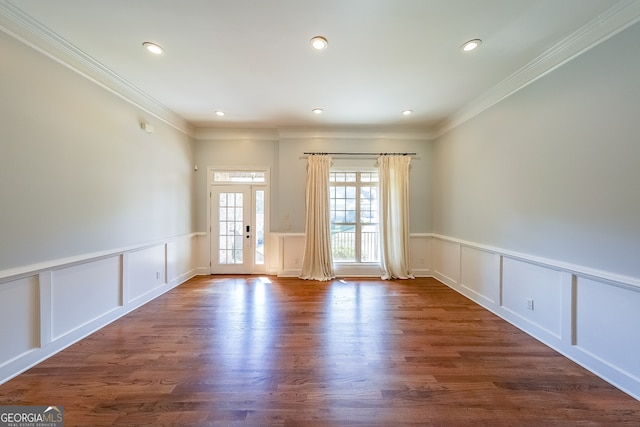 empty room with dark hardwood / wood-style flooring and crown molding