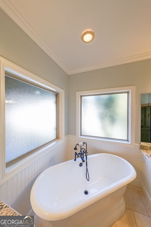 bathroom featuring a bath, tile patterned flooring, a healthy amount of sunlight, and ornamental molding