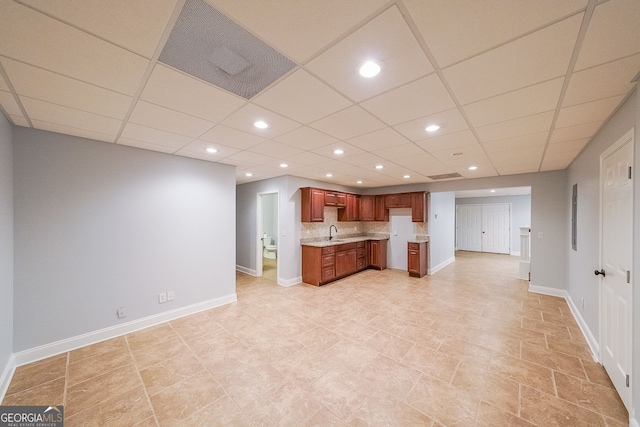 kitchen with decorative backsplash, a drop ceiling, and sink