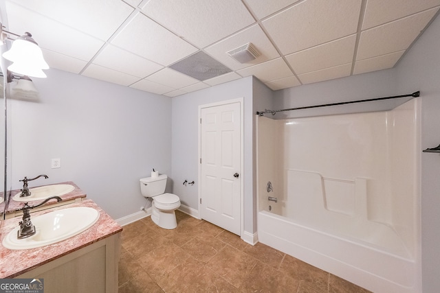 full bathroom with a paneled ceiling, toilet, vanity, and washtub / shower combination