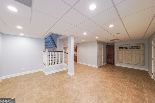 basement featuring a drop ceiling and light tile patterned flooring