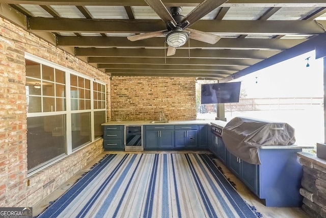 view of patio with area for grilling, ceiling fan, beverage cooler, sink, and grilling area