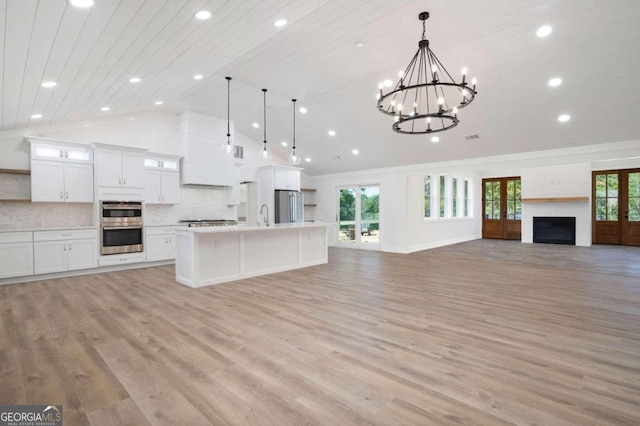 kitchen with a wealth of natural light, pendant lighting, and light wood-type flooring