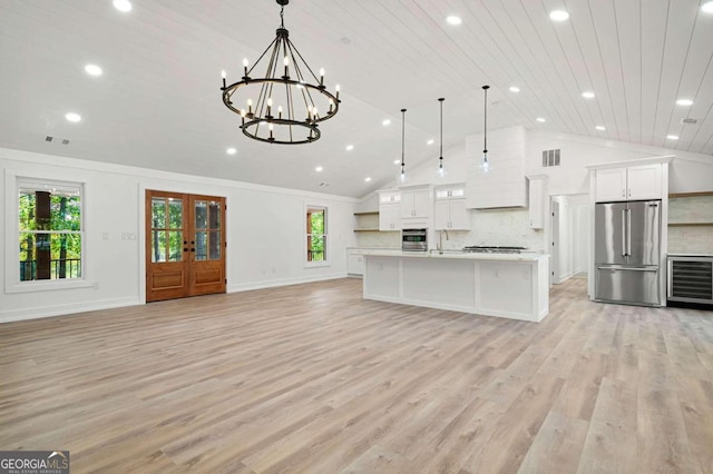 kitchen featuring appliances with stainless steel finishes, decorative light fixtures, and plenty of natural light