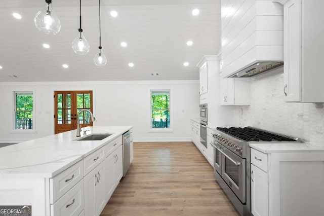 kitchen with sink, stainless steel appliances, white cabinetry, and decorative light fixtures