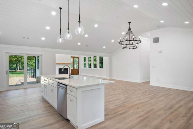 kitchen featuring sink, vaulted ceiling, pendant lighting, stainless steel dishwasher, and a kitchen island with sink