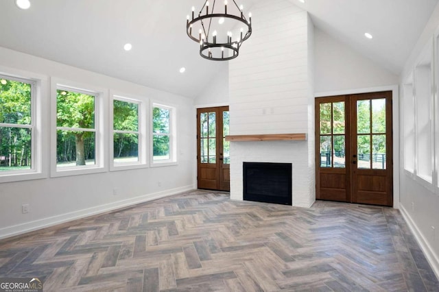 unfurnished living room featuring a chandelier, french doors, high vaulted ceiling, and baseboards