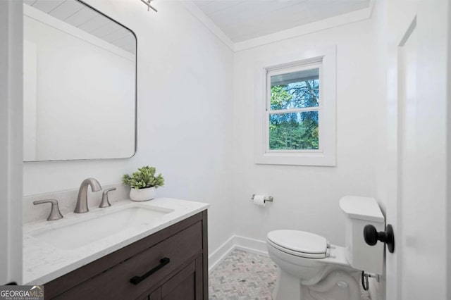 half bathroom with toilet, ornamental molding, vanity, and baseboards