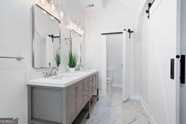 bathroom with a sink, toilet, marble finish floor, visible vents, and double vanity