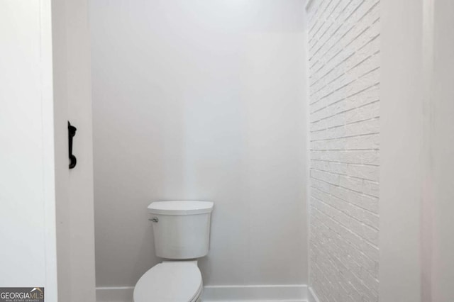 bathroom with toilet and baseboards