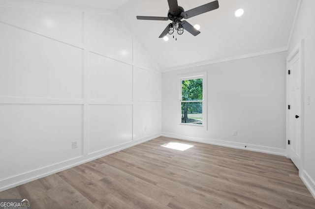empty room with ceiling fan, crown molding, light wood-style flooring, and vaulted ceiling