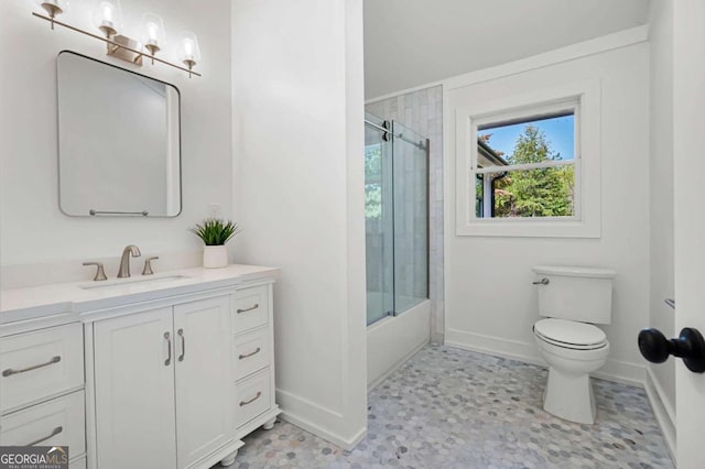 bathroom with baseboards, toilet, enclosed tub / shower combo, and vanity