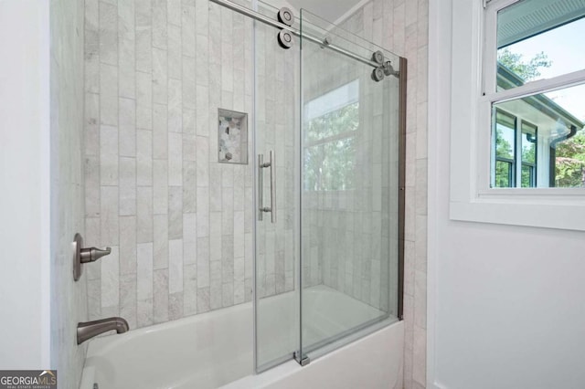 bathroom with bath / shower combo with glass door