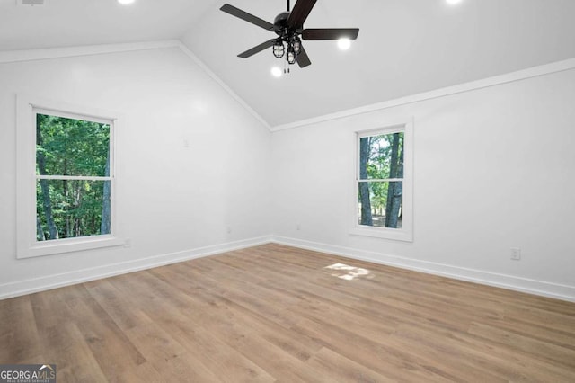 empty room with light wood-style floors, ornamental molding, vaulted ceiling, and baseboards