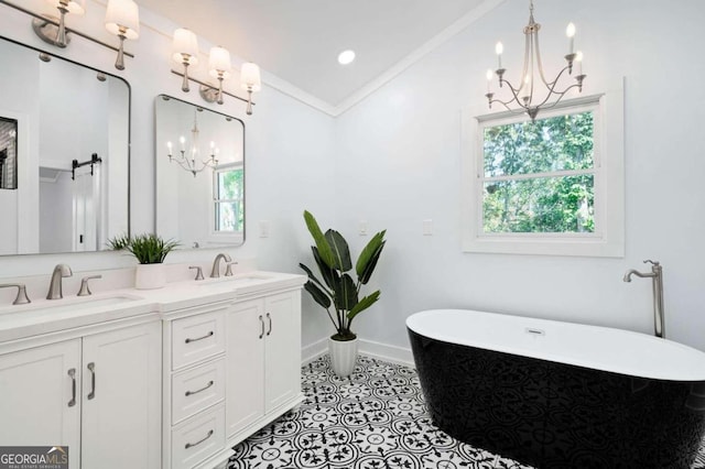 full bathroom featuring a sink, double vanity, a notable chandelier, and a freestanding tub