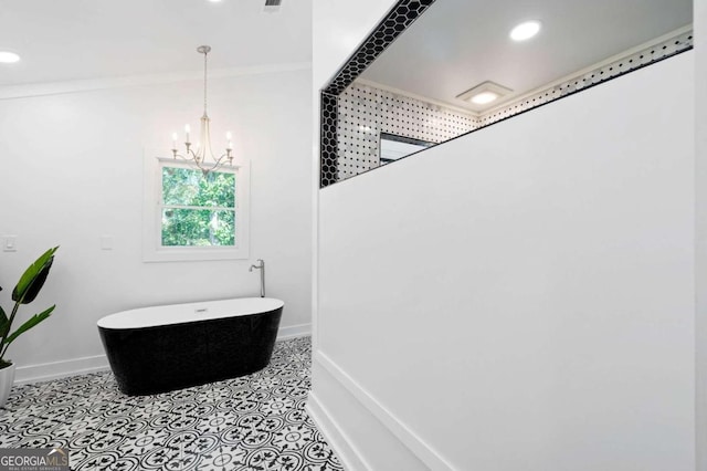 bathroom featuring ornamental molding, an inviting chandelier, and a tub