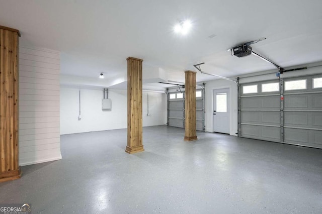 garage with a garage door opener and electric panel