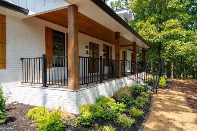 view of property exterior featuring a porch and brick siding