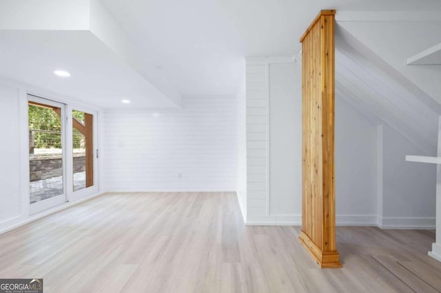 additional living space featuring light hardwood / wood-style floors and vaulted ceiling