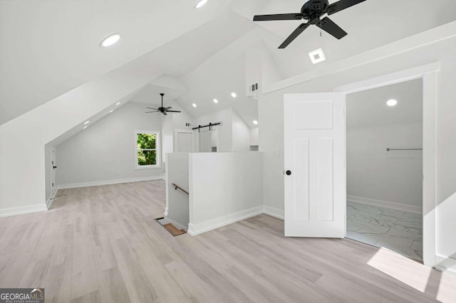 additional living space featuring lofted ceiling, a barn door, a ceiling fan, and recessed lighting