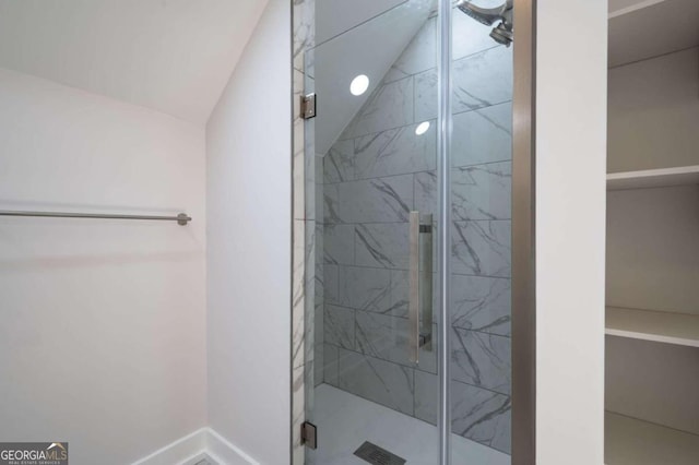 full bathroom featuring a shower stall, vaulted ceiling, and baseboards