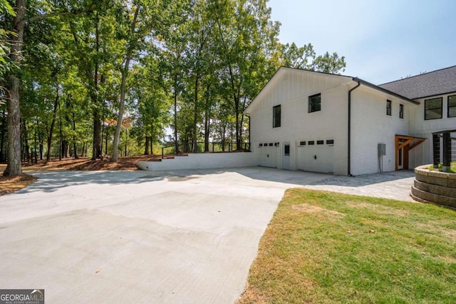 view of side of property with driveway and an attached garage