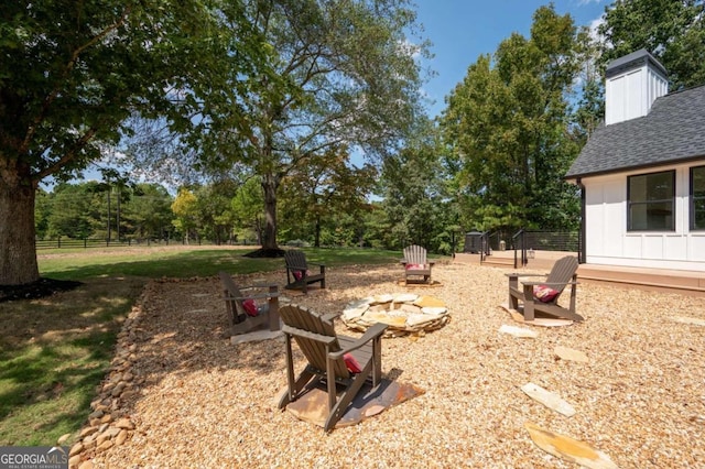view of yard with a fire pit and fence