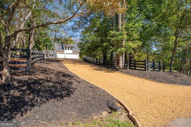 view of yard with fence, concrete driveway, and an attached garage