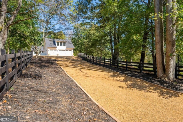 view of yard featuring driveway, fence, and a garage
