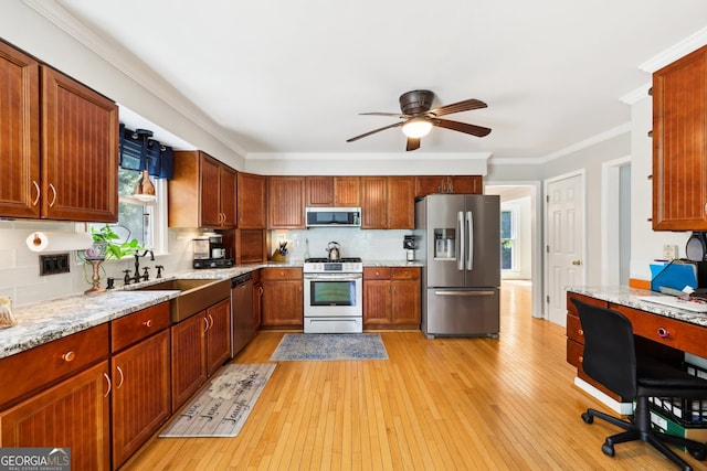 kitchen with tasteful backsplash, appliances with stainless steel finishes, light stone countertops, light hardwood / wood-style flooring, and crown molding