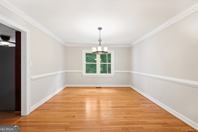 unfurnished dining area with light hardwood / wood-style floors, ornamental molding, and ceiling fan with notable chandelier