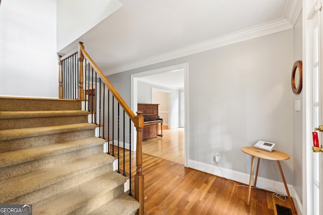 stairway featuring hardwood / wood-style flooring and ornamental molding