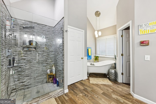 bathroom with hardwood / wood-style flooring, plus walk in shower, and vaulted ceiling