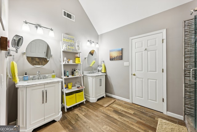 bathroom featuring vanity, hardwood / wood-style flooring, and vaulted ceiling